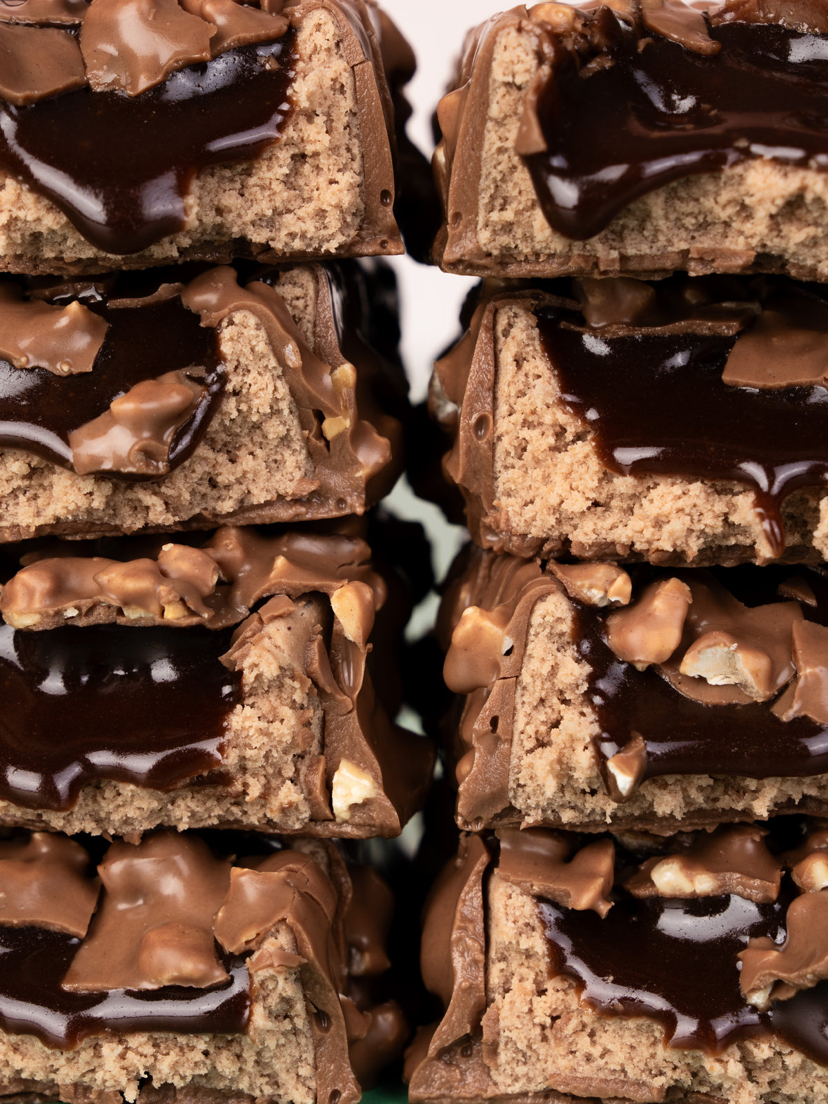 Stacked Barebells Hazelnut Spread protein bars showing cross-sections with tan cake layers and dark chocolate coating with hazelnut pieces