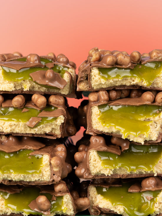 Close-up of Barebells Pistachio Spread bars with green pistachio layer, chocolate coating and spheres